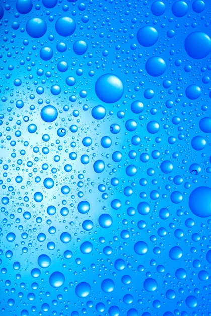 Crystal clear water drops over blue background