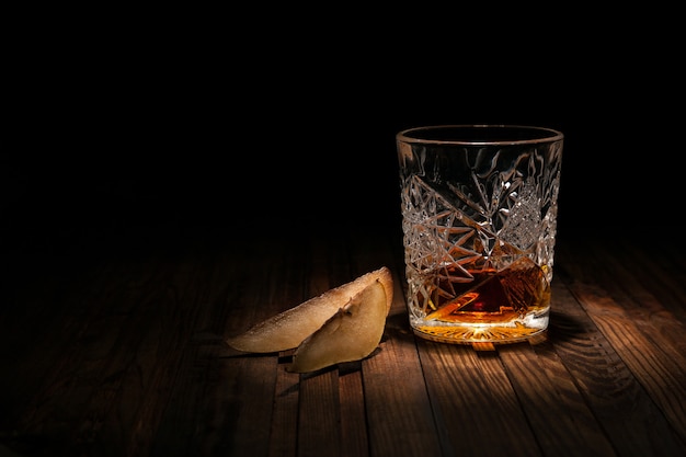 Crystal glass of whiskey on a wooden table on black 