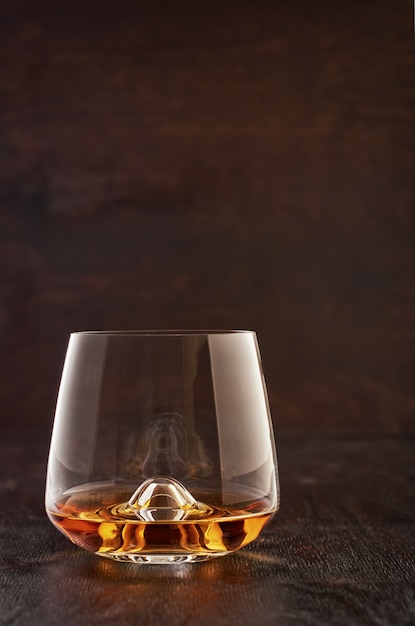 Crystal glass with whiskey on a wooden table