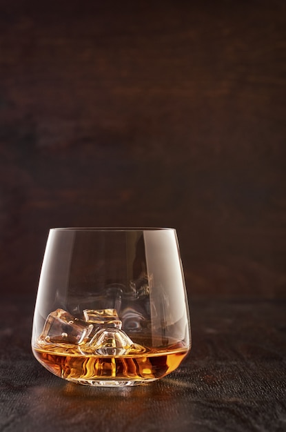 Crystal glass with whiskey on a wooden table