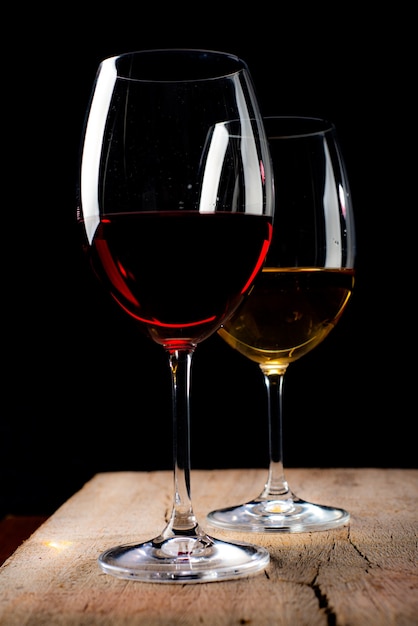 Crystal glasses with red and white wineover rustic wooden table