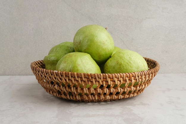 Crystal guava psidium guajava o jambu kristal servito in cesto di rattan su sfondo grigio