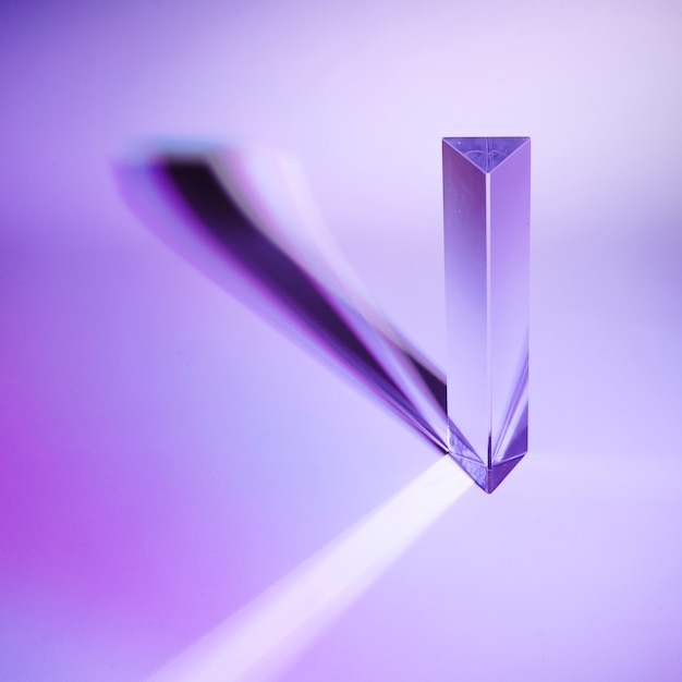 Photo crystal prism with dark shadow on purple background