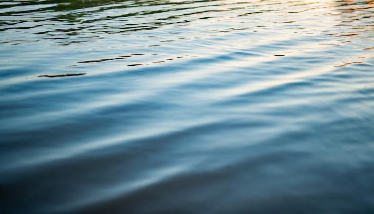 Photo crystalclear water surface reflecting vibrant blue sky symbolizing purity tranquility and sereni
