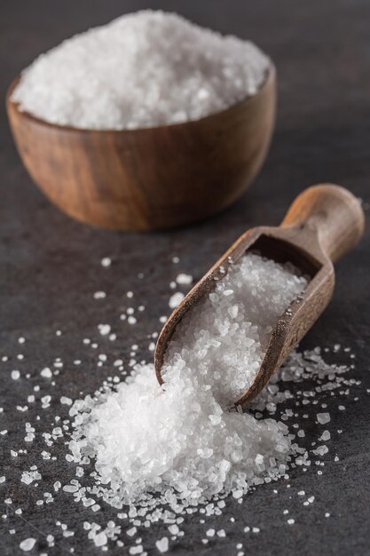 Photo crystaline sea salt in bowl and spoon closeup