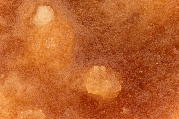 Crystalized honey - almost solid amber coloured substance, closeup detail image width 23mm