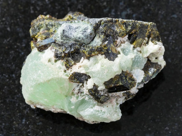 Crystals of Epidote on prehnite gemstone on dark