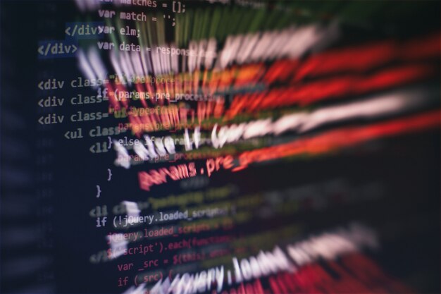 CSS、JavaScript、およびHTMLの使用法。関数のソースコードのクローズアップを監視します。抽象的なIT技術の背景。ソフトウェアのソースコード。