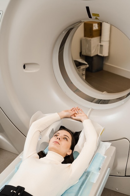 의료 클리닉에 있는 여성의 복부 CT 스캔 소녀 환자가 CT 스캔실에서 복부 검사를 위해 가슴의 CT 컴퓨터 단층 촬영 xray 스캔을 하고 있습니다.