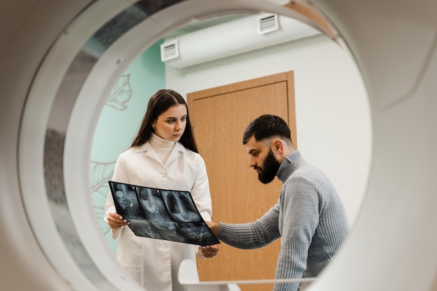 컴퓨터 단층촬영실에서 환자에게 복부의 엑스레이를 보여주는 CT 스캔 방사선과 CT 의사 상담 환자 및 컴퓨터 단층 촬영실에서 환자에게 흉부 엑스레이