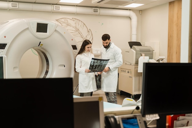 의료 클리닉에서 폐암에 대한 CT 엑스레이 검사 의료 클리닉에서 폐암 진단을 논의하는 컴퓨터 단층 촬영 스캔의 엑스레이를 가진 동료 의사