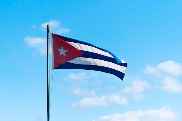 Cuba country flag fluttering on flagstaff under blue sky