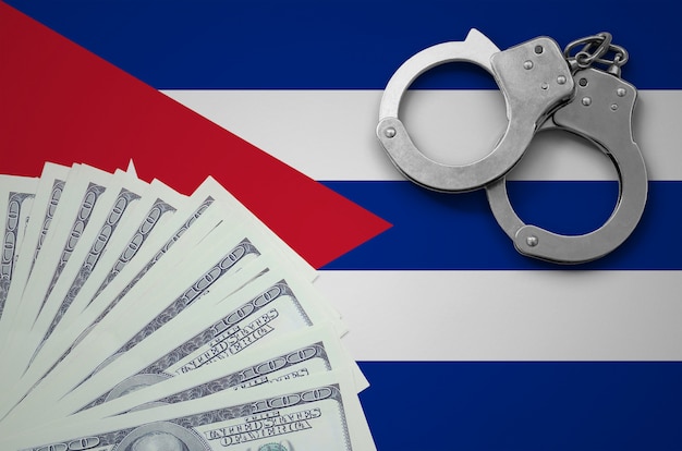 Bandiera di cuba con le manette e un pacco di dollari. il concetto di operazioni bancarie illegali in valuta statunitense