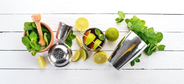 Cuba libre cocktail glass Lime mint On a white wooden background Free space for text