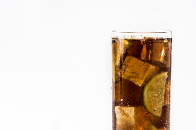 Cuba libre cocktail met rum, limoen en ijs op wit wordt geïsoleerd.