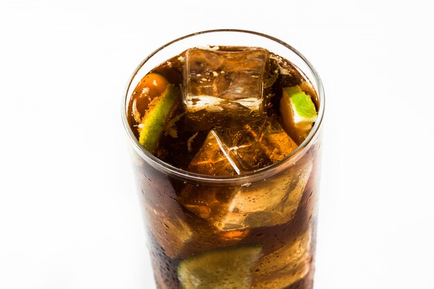 Foto cuba libre cocktail con rum, calce e ghiaccio isolati su bianco.