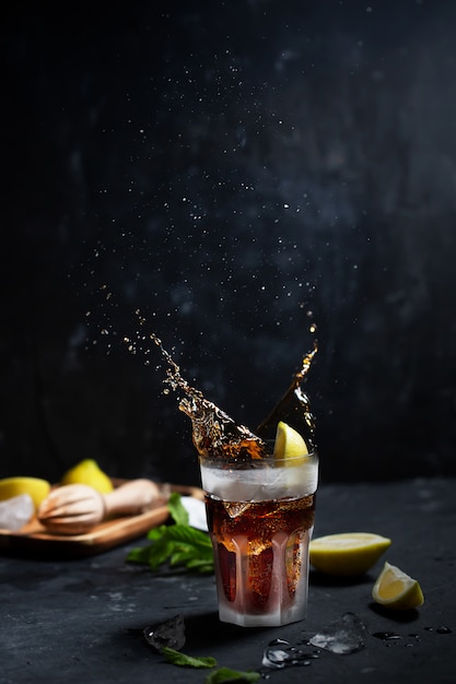 Cuba Libre or Long Island iced cocktail with strong drinks, cola, lemon and ice