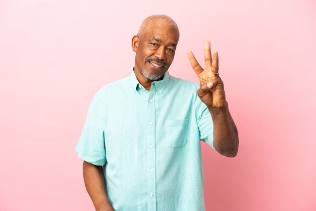 Cubaanse senior geïsoleerd op roze achtergrond gelukkig en drie tellen met vingers