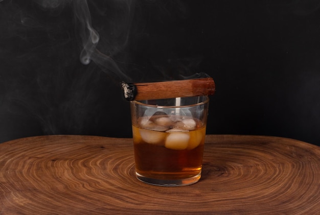 Cubaanse sigaar en glas met whisky op houten tafel