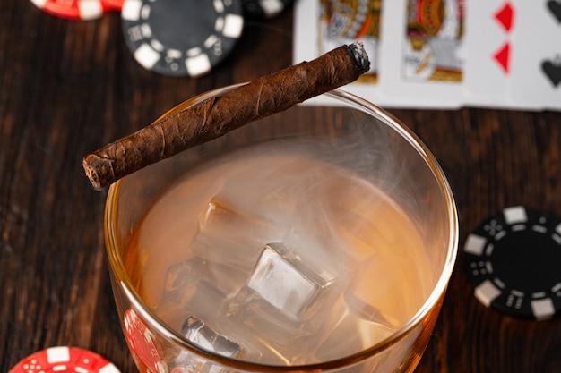 写真 テーブルの上にキューバ産の葉巻ウイスキーグラスとチップス