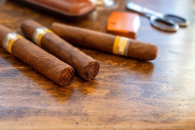 Cuban cigars and smoking accessories on wooden desk