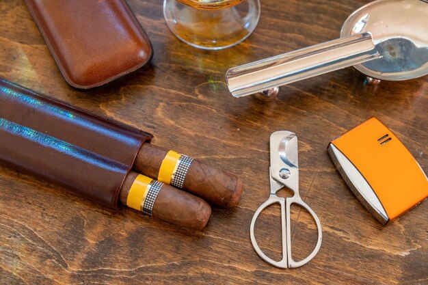 Photo cuban cigars and smoking accessories on wooden desk