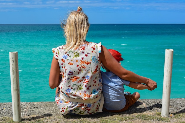 A cuban girl and a cuban boy admire the azure water of the\
ocean varadero cuba 2019