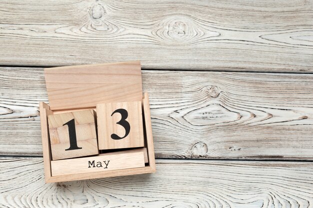 Cube calendar for may 13th on wood with copy space