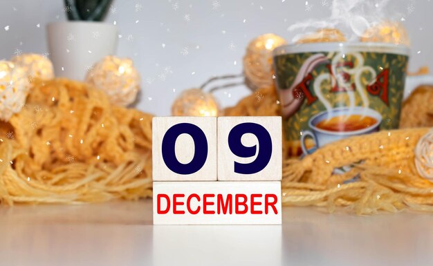 Photo cube shape calendar for december 09 on wooden surface with empty space for text