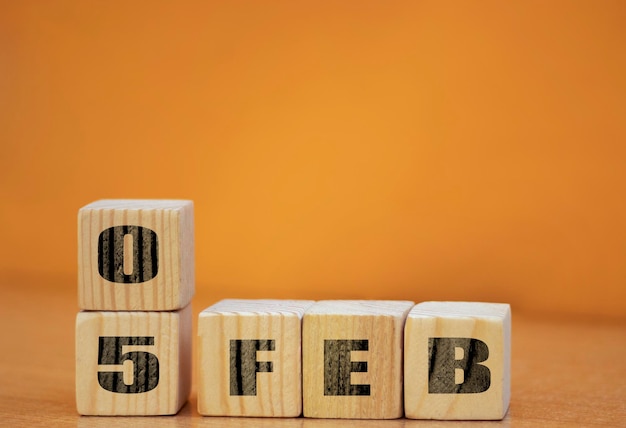 Cube shape calendar for February 05 on wooden surface with empty space for text new year