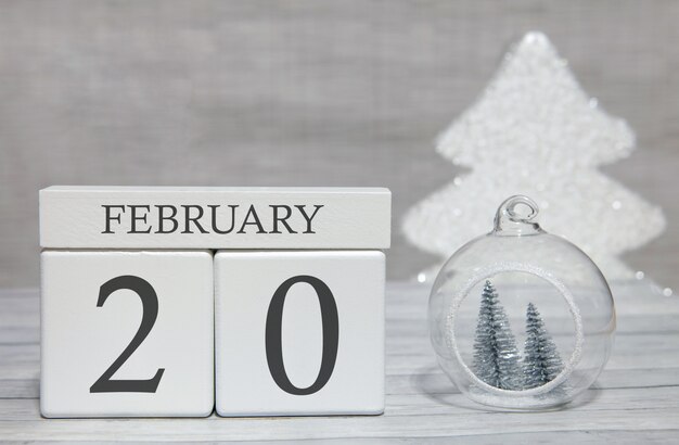 Cube shape calendar for February 20 on wooden surface and light background