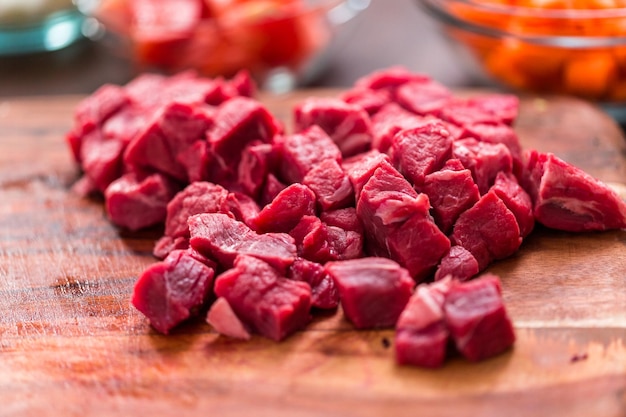 Cubed beef sirloin on wood cutting board.