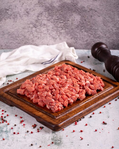 Cubed meat Chopped red meat in a wooden serving dish on a stone background Butcher products close up