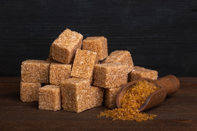 Photo cubes of cane sugar and a wood spoon with sugar