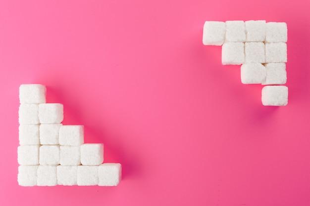 Cubes of sugar over pink surface