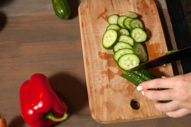 A cucumber is cuted into rings at the table