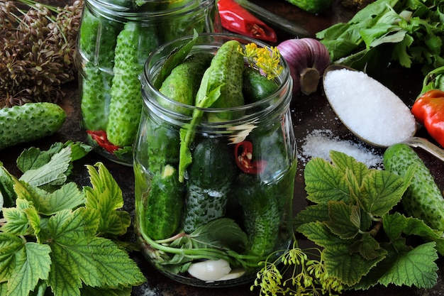 Cucumber pickling concept with jars of cucumbers, herbs and spices