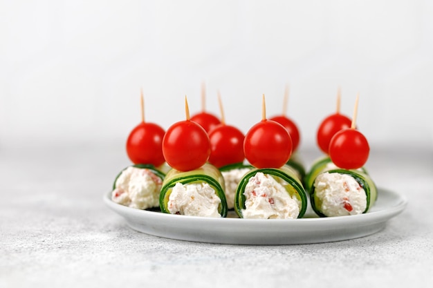 Cucumber rolls stuffed with cream cheese Holiday snack for a festive table Mini fresh canapes