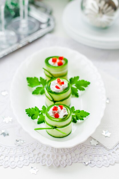 Photo cucumber rolls stuffed with feta cheese, herbs, capsicum and black olives