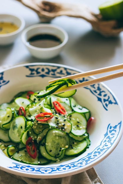 Cucumber salad in Chinese chopsticks, Asian cuisine, spices