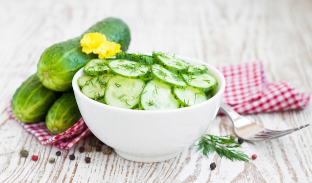 cucumber salad garnished with dill in white bowl