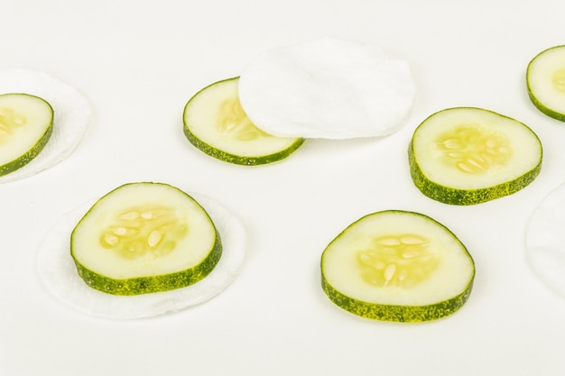 Cucumber slices and cotton pads isolated on white background. Homemade cosmetics concept