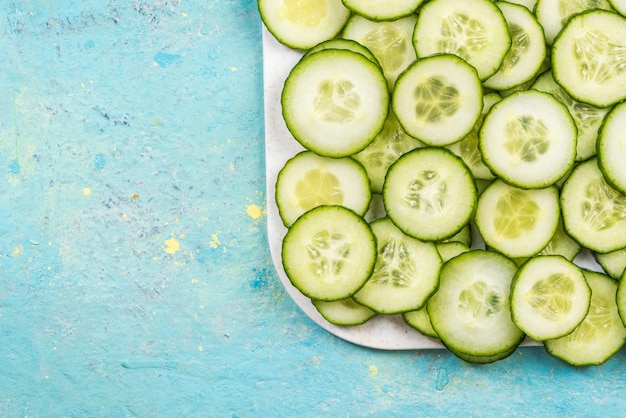 Cucumber slices food border background on white marble