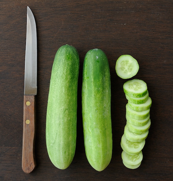 Cucumber slices and  Knife on wooden table