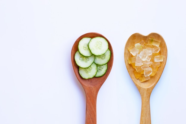 Cucumber slices with aloe vera gel in wooden spoon on white