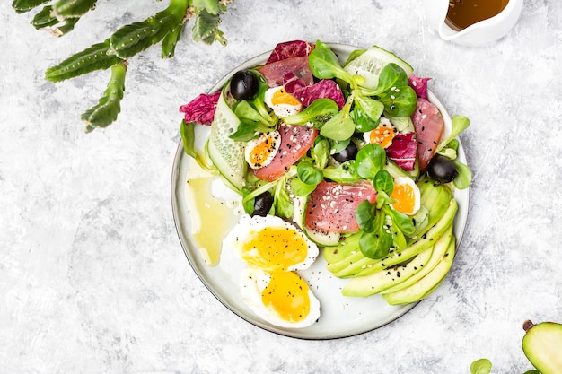 Cucumber, smoked tuna and avocado salad with egg and olives