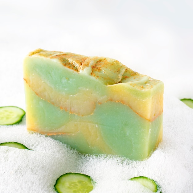 Photo cucumber soap in soapy foam close-up.