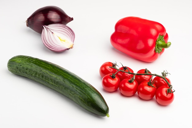 Cucumber, sweet pepper, red onion, cherry tomatoes on a white background, isolated