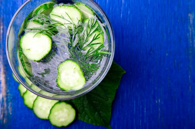 Acqua del cetriolo in vetro con aneto su di legno blu. detox, dieta.