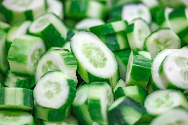 Photo cucumbers green cut into pieces in bulk selective focus